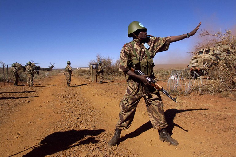 A Mozambican soldier directs traffic at a checkpoint during an excercise 22 April in Lahatla army camp in the Northern Cape province, some 600 km west of Johannesburg. Soldiers from 12 South African development community (SADC) countries participated in the excercise "Blue crane" to coordinate and train for future peacekeeping operations. (ELECTRONIC IMAGE) / AFP / ODD ANDERSEN