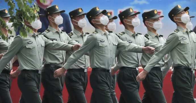 Chinese People's Liberation Army (PLA) soldiers wearing face masks to protect against the spread of the new coronavirus march past a banner depicting Chinese President Xi Jinping at their living squatter inside the Tiananmen Gate in Beijing during a plenary session of China's National People's Congress (NPC) at the Great Hall of the People in Beijing, Monday, May 25, 2020. (AP Photo/Andy Wong)