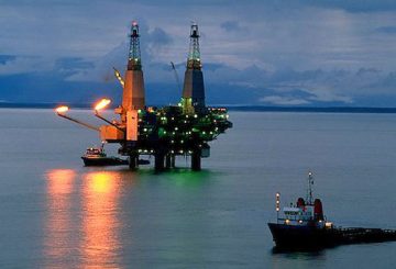 Alaska. Cook Inlet. Dolly Varden off shore oil rig. Oil drilling platform at night with work boats.