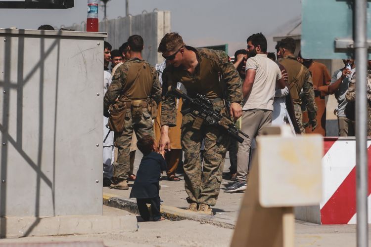US Marine plays with a child during an evacuation at Hamid Karzai International Airport, Kabul, Afghanistan 210821 CREDIT US DEPARTMENT OF DEFENSE