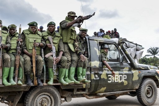 Soldier of the FARDC (Armed Forces of the Democratic Republic of the Congo) sit on a military vehicle in an area of exchanges of fire with members of the ADF (Allied Democratic Forces) in Opira, North Kivu, on January 25, 2018. (Photo by ALAIN WANDIMOYI / AFP)